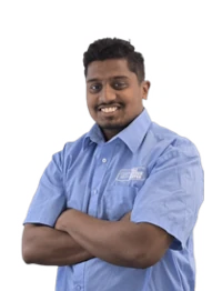 Mitarbeiter mit Firmenhemd lächelt freundlich und verschränkt die Arme vor weißem Hintergrund.